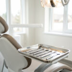 Comment diversifier l'offre d'un cabinet dentaire pour attirer plus de patients Cabinet dentaire moderne et lumineux, chaise de consultation préparée avec des instruments propres sur un plateau inox, ambiance professionnelle accueillante.